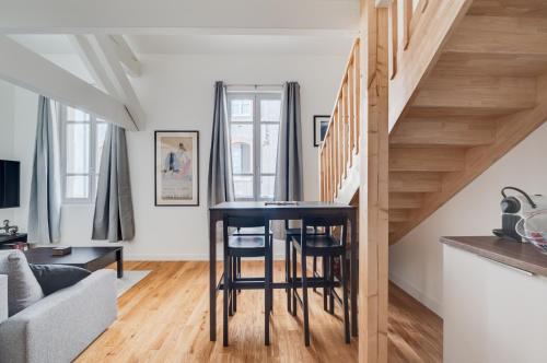 Il comprend une cuisine et un salon avec une table et des escaliers. dans l'établissement Style et caractère, climatisation, à Toulouse