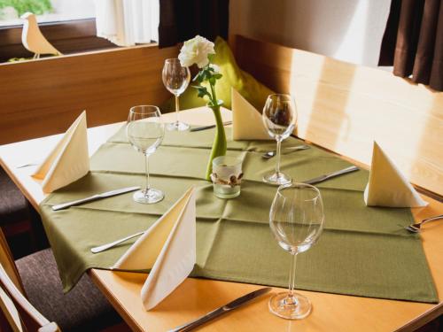 a table set with wine glasses and flowers on it at Gasthof Seehof in Illmensee