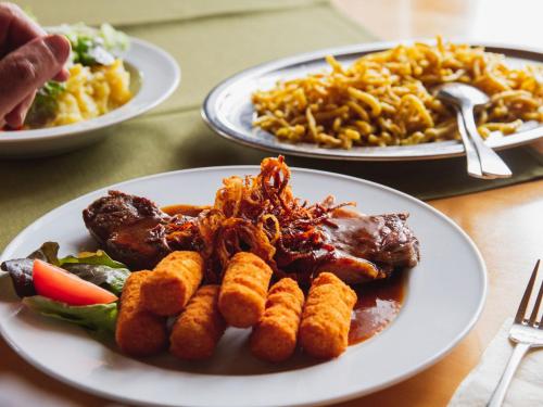 three plates of food on a table with plates of food at Gasthof Seehof in Illmensee