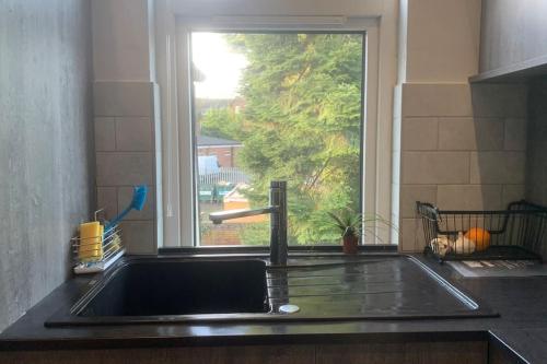 a sink in a kitchen with a window at A quiet haven in the city in Birmingham