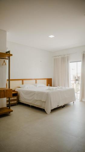 a bedroom with a large bed with white sheets at Casa reserva boa vista in Barreirinhas