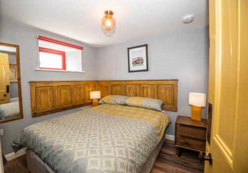 a bedroom with a bed and two lamps and a mirror at Bartholomew's Loft in Ráistín