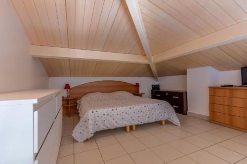 une chambre avec un lit et un plafond en bois dans l'établissement Bella Vista Porticcio - Appt climatisé, à Grosseto-Prugna