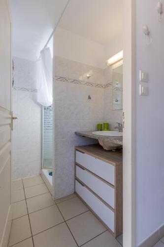 une salle de bain blanche avec un lavabo et une douche dans l'établissement Bella Vista Porticcio - Appt climatisé, à Grosseto-Prugna