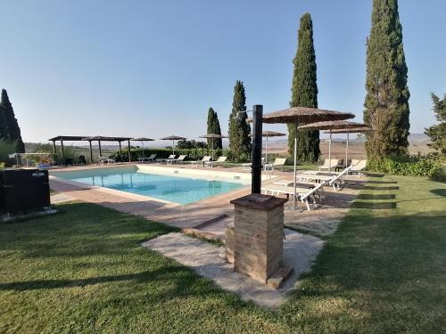 - une piscine avec une table et un parasol dans l'établissement Agriturismo Carpineto, à Asciano