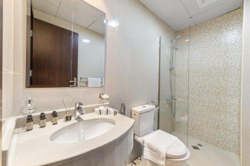 uma casa de banho com um lavatório, um WC e um chuveiro em Silkhaus Chic Studio Near Silicon Oasis Shopping Mall em Dubai