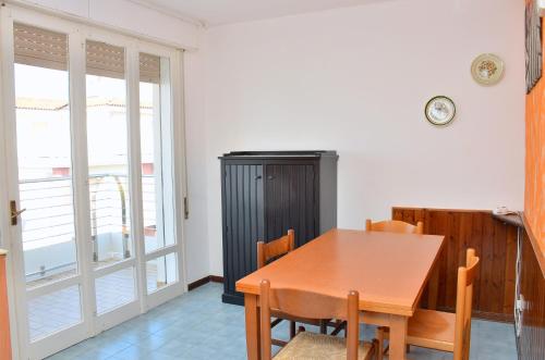 uma sala de jantar com uma mesa de madeira e cadeiras em Condominio Adriatico em Bibione