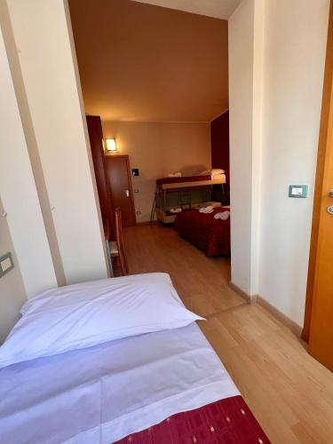 a bedroom with a white bed in a room at Hotel Villa Tina in Cesenatico