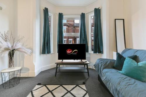 a living room with a couch and a table at Prime Location Stylish 4-Bed House near Trent Br in Nottingham