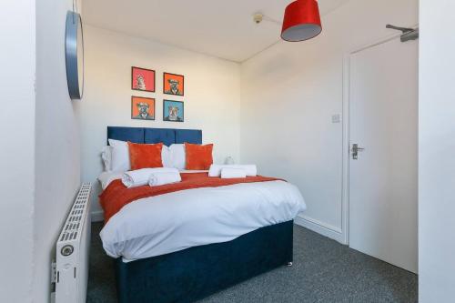 a bedroom with a blue bed with orange pillows at Prime Location Stylish 4-bed House Near Trent Br in Nottingham