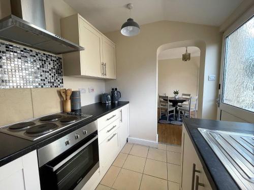 a kitchen with white cabinets and a stove top oven at 3-bed House In Grantham in Lincolnshire