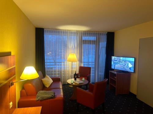 a hotel room with a couch and a television at Seeblick 212 in Hahnenklee-Bockswiese