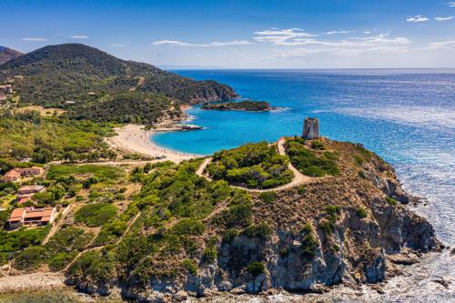 an island in the ocean with a lighthouse on it at Veridia Resort Sardinia, a member of Radisson Individuals in Chia
