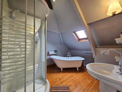 une salle de bain avec une baignoire blanche et un lavabo dans l'établissement Soleil du Matin, à Étretat