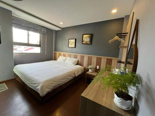 a bedroom with a bed and a table with a plant at MINH NGUYÊN 145 in Da Lat