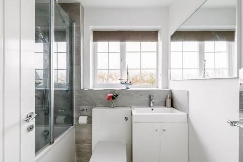 a white bathroom with a sink and a shower at Leap House in Wareham