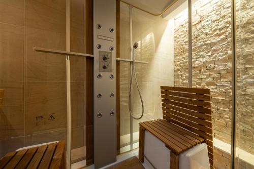 y baño con ducha y banco de madera. en Villa Barotul, en Pašman