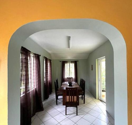 a dining room with a table and chairs and an archway at Kay Marni: Your Saint Lucian home in Gros Islet