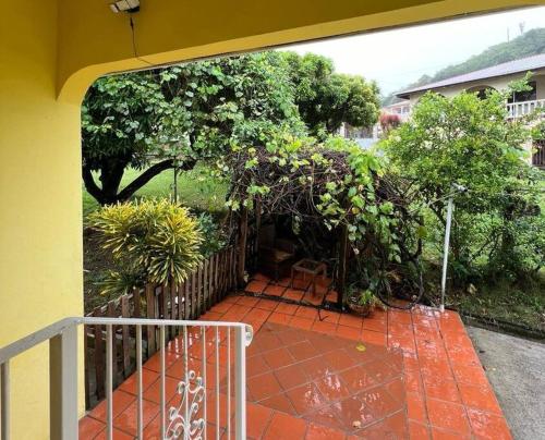 a patio with a fence and trees and plants at Kay Marni: Your Saint Lucian home in Gros Islet