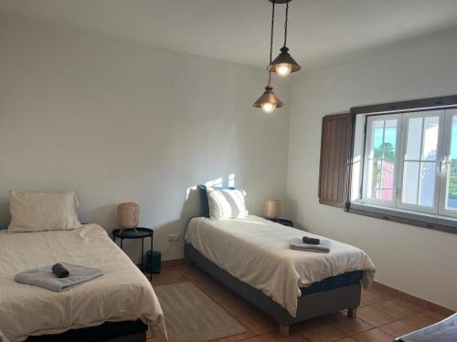 een slaapkamer met 2 bedden en een raam bij Quinta Kaleidoscope in Vendas Novas