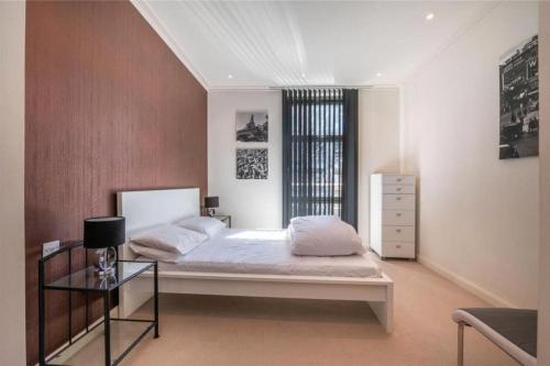 um quarto com uma cama grande e uma mesa de vidro em Luxury Penthouse 2 bedrooms flat in Canary Wharf em Londres