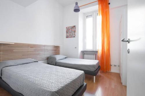 ローマにあるTrastevere St. Garden Houseのベッドルーム1室(ベッド2台、オレンジ色のカーテン付)