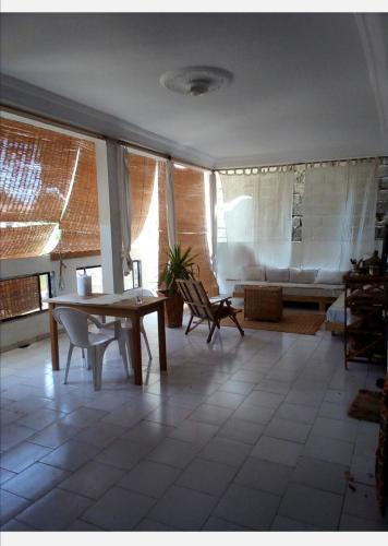 a living room with a table and a couch at Maison Manour, chambre 'Tribal' in Mbour