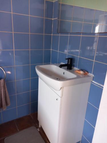 a bathroom with a white sink and blue tiles at ΠΕΤΡΟΚΤΙΣΤΟ in Kakopetria