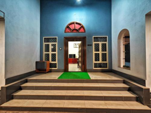 an empty room with a door and a green floor at Sirimudi Villa in Kundapur