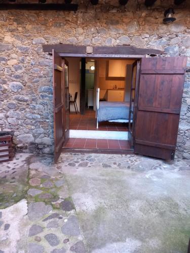 une porte ouverte dans un bâtiment en pierre avec un lit dans l'établissement ΠΕΤΡΟΚΤΙΣΤΟ, à Kakopetriá
