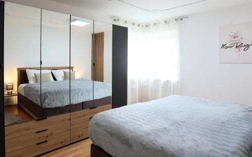 a bedroom with a bed and a large glass cabinet at Premium 106 m2 Wohnung Top für München/Oberbayern in Geretsried