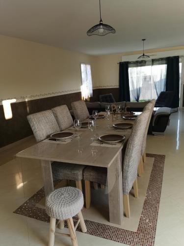 une table en bois avec des chaises et une salle à manger dans l'établissement Maison de la Solinoise, à Sainte-Soulle