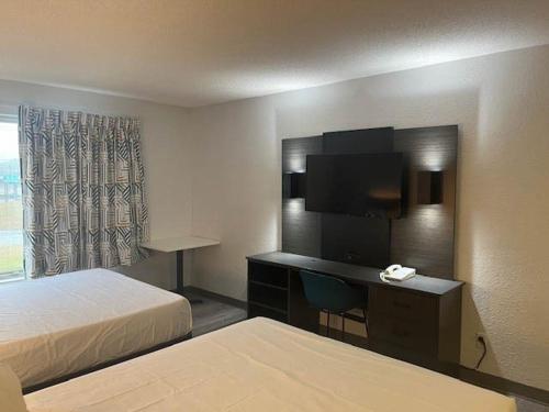 a hotel room with a bedroom with a desk and a bed at Studio 6 Suites Norcross, GA in Norcross