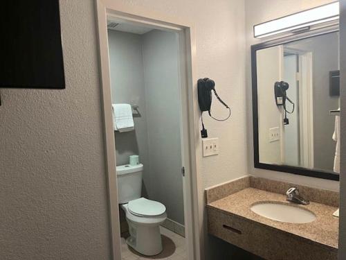 a bathroom with a toilet and a sink and a phone at Studio 6 Suites Norcross, GA in Norcross