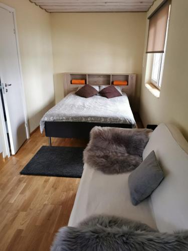a bedroom with a bed and a couch at Līdumnieki in Vērgale