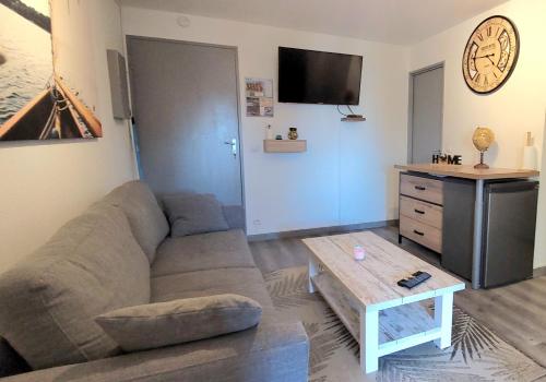 a living room with a couch and a coffee table at La voile au Lamparo - T2 climatisé - parking in Port Leucate