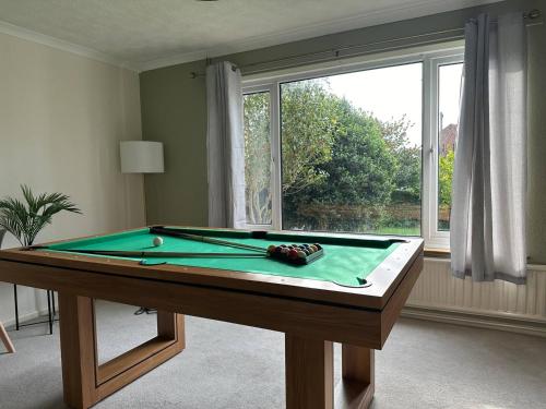 een pooltafel in een kamer met een raam bij 3 Bed House - Parking - Pool Table - Close to A1 in Balderton