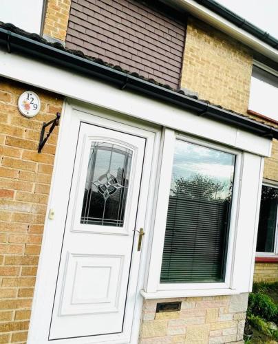 a white door with a window on a brick house at 3 Br House - Private Parking - Pool Table in Balderton