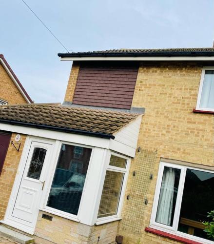a house with white doors and a brown roof at 3 Br House - Private Parking - Pool Table in Balderton