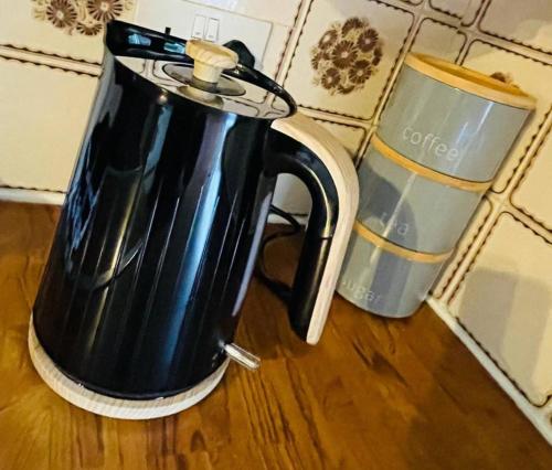 a black coffee pot sitting on top of a table at 3 Br House - Private Parking - Pool Table in Balderton