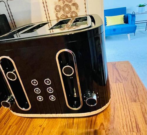 a toaster sitting on top of a wooden table at 3 Br House - Private Parking - Pool Table in Balderton