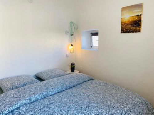 een slaapkamer met twee blauwe bedden en een foto aan de muur bij Les Logis de la Combette in Saint-Rémy-de-Provence