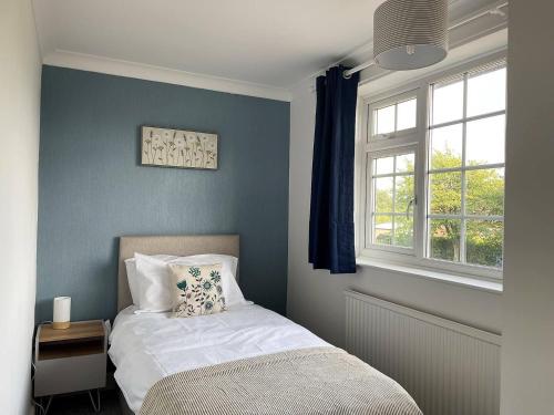 sypialnia z łóżkiem i oknem w obiekcie Spacious 5-bed - Perfect For Contractors 