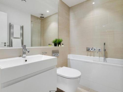 ein Badezimmer mit einem Waschbecken, einem WC und einer Badewanne in der Unterkunft 3 bedroom penthouse with balcony in London