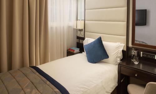 a hotel room with a bed with a blue pillow at Montcalm Brewery Townhouse in London