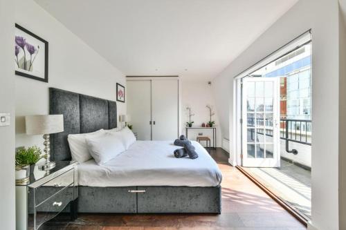 ein Schlafzimmer mit einem Bett mit einem Teddybär drauf in der Unterkunft 3 bedroom penthouse with balcony in London