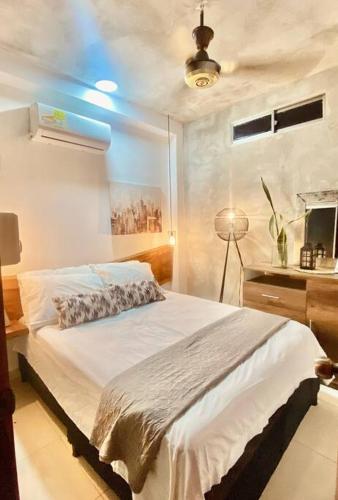 1 dormitorio con cama blanca y escritorio en Cómodo Apartamento céntrico, en Mompox
