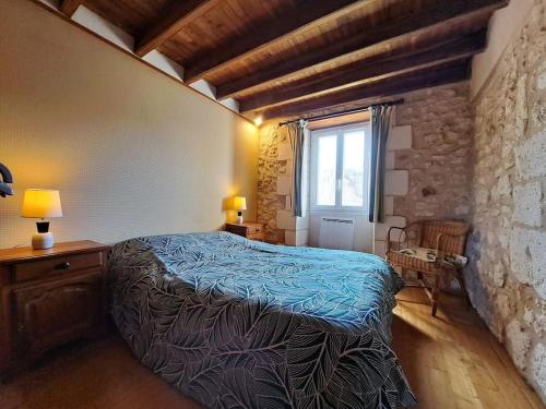 une chambre avec un lit dans une pièce avec une fenêtre dans l'établissement Périgord Vert - Animaux acceptés, à Quinsac