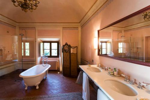 a large bathroom with two sinks and a large mirror at Borgo Pignano Tuscany in Pignano