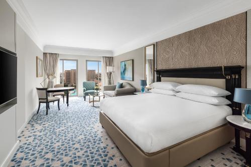 カイロにあるインターコンチネンタル カイロ シティスターズの大きなベッドとデスクが備わるホテルルームです。